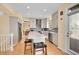 Modern kitchen with a large island, stainless steel appliances, and open to the dining area at 9411 La Quinta Way, Lone Tree, CO 80124
