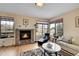 Bright living room features a brick fireplace, hardwood floors, and large windows with views at 9411 La Quinta Way, Lone Tree, CO 80124