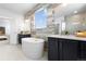 Spa-like bathroom featuring a freestanding tub, dual vanities, and a modern tile accent wall at 1060 Coal Bank Trl, Castle Rock, CO 80104