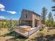 Stunning outdoor space with a deck, hot tub, barbecue, and comfortable seating, perfect for relaxing with mountain views at 6574 Olympus Dr, Evergreen, CO 80439