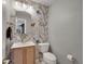 Charming powder room featuring designer wallpaper, wood vanity, and a stylish mirror at 6574 Olympus Dr, Evergreen, CO 80439