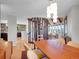 Spacious dining room with wood floors, contemporary lighting, and an open floor plan to kitchen at 6574 Olympus Dr, Evergreen, CO 80439
