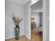 Hallway with unique vase, light hardwood floors, and an open doorway that offers a glimpse into a bedroom at 6574 Olympus Dr, Evergreen, CO 80439