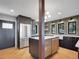 Modern kitchen with stainless steel appliances, custom cabinets, island, and an exterior door at 6574 Olympus Dr, Evergreen, CO 80439