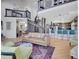 Spacious living room with hardwood floors, comfortable seating, spiral staircase, open to modern kitchen with breakfast bar at 6574 Olympus Dr, Evergreen, CO 80439