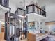 Open-concept living room featuring a unique spiral staircase, modern kitchen, and lofted library area with stylish decor at 6574 Olympus Dr, Evergreen, CO 80439