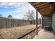 Large backyard space with a wood fence, patio area and mature trees in a partially shaded area at 865 S Quebec St # 103B, Denver, CO 80247