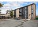Apartment building exterior featuring a parking area, balconies and well maintained landscaping at 865 S Quebec St # 103B, Denver, CO 80247