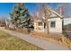 Street view of a charming home featuring a fenced yard and well-maintained landscaping at 3135 California St, Denver, CO 80205