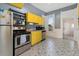Efficient kitchen featuring bright yellow cabinets and eye-catching patterned floors at 3135 California St, Denver, CO 80205