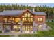 Home's back exterior, boasting stone accents, balcony, and outdoor living spaces perfect for relaxation and entertainment at 242 Point View Pl, Breckenridge, CO 80424