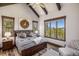 Bright bedroom with wood trim and flooring, large windows, and views of the outdoors at 242 Point View Pl, Breckenridge, CO 80424
