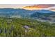 Stunning mountain home surrounded by forest, featuring panoramic views and a serene setting at sunset at 242 Point View Pl, Breckenridge, CO 80424