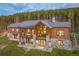 Stunning two-story home with a stone foundation and a backdrop of towering pine trees at 242 Point View Pl, Breckenridge, CO 80424