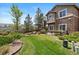 Beautifully landscaped backyard with lush grass, a wooden fence, and mature trees at 22044 E Jamison Pl, Aurora, CO 80016