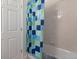 Bright bathroom with a colorful shower curtain and a clean, well-maintained bathtub and shower area at 22044 E Jamison Pl, Aurora, CO 80016
