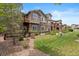 A multi-level home boasts stone accents, a walkout basement, a small balcony, and lush landscaping at 22044 E Jamison Pl, Aurora, CO 80016
