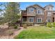 A multi-level home boasts stone accents, a walkout basement, a small balcony, and mature landscaping at 22044 E Jamison Pl, Aurora, CO 80016