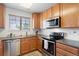 Charming kitchen with stainless steel appliances, wood cabinetry, and cozy design at 22044 E Jamison Pl, Aurora, CO 80016