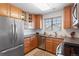 Bright kitchen with stainless steel appliances, wood cabinetry, and natural light at 22044 E Jamison Pl, Aurora, CO 80016