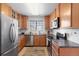 Traditional kitchen with stainless steel appliances, wood cabinetry, and window view at 22044 E Jamison Pl, Aurora, CO 80016