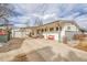 House front with attached carport and landscaping at 1671 S Chase St, Lakewood, CO 80232