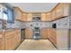Updated kitchen, featuring stainless steel appliances and light wood cabinets at 1671 S Chase St, Lakewood, CO 80232