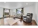 Spacious living room with hardwood floors, comfortable seating, and large windows at 1671 S Chase St, Lakewood, CO 80232