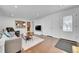 Living area with hardwood floors, a view into the kitchen, and a modern TV setup at 1671 S Chase St, Lakewood, CO 80232