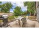 Outdoor patio area with table and chairs, barbecue grill, and lush greenery at 3358 S Iris Ct, Lakewood, CO 80227