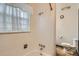 Bright bathroom featuring a shower-tub combination with white tiling, and toilet at 3358 S Iris Ct, Lakewood, CO 80227