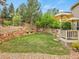 Landscaped backyard with deck, retaining walls, mature trees, and lush lawn at 7138 Mountain Brush Cir, Highlands Ranch, CO 80130