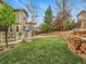 Expansive backyard featuring a deck, retaining wall, and mature trees at 7138 Mountain Brush Cir, Highlands Ranch, CO 80130