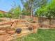 Backyard featuring natural stone steps and retaining walls with lush greenery at 7138 Mountain Brush Cir, Highlands Ranch, CO 80130