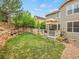 Large backyard with deck, retaining wall, grass, and mature trees at 7138 Mountain Brush Cir, Highlands Ranch, CO 80130