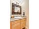 Stylish powder room with granite counters, decorative mirror and light wood cabinets at 7138 Mountain Brush Cir, Highlands Ranch, CO 80130