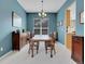 Formal dining room with blue walls, neutral carpet, wainscoting, and a chandelier lighting fixture at 7138 Mountain Brush Cir, Highlands Ranch, CO 80130