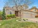 Charming two-story home featuring a manicured lawn, mature trees, and a brick facade at 7138 Mountain Brush Cir, Highlands Ranch, CO 80130