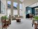 Bright living room with tall windows, neutral colors, and open floor plan into the dining area at 7138 Mountain Brush Cir, Highlands Ranch, CO 80130