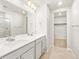 Bathroom with a double sink vanity, tile flooring and an open doorway to the walk-in closet at 17487 E 89Th Way, Commerce City, CO 80022