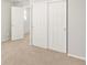 Bedroom featuring neutral carpet, white walls, closet with sliding doors and an open doorway at 17487 E 89Th Way, Commerce City, CO 80022