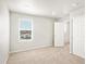 Bright bedroom with a window overlooking the exterior, neutral carpet and white walls at 17487 E 89Th Way, Commerce City, CO 80022