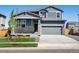Charming two-story home with stone accents and a well-manicured lawn during daytime at 17487 E 89Th Way, Commerce City, CO 80022