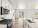Modern kitchen with stainless appliances, granite countertops, and open to living room at 17487 E 89Th Way, Commerce City, CO 80022