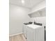 Laundry room with a washer and dryer, light wood look flooring and a wire shelf at 17487 E 89Th Way, Commerce City, CO 80022