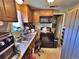 Efficient kitchen features classic wood cabinets, a black appliance suite, and tiled flooring at 6060 Locust St, Commerce City, CO 80022