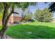 Spacious backyard features a lush green lawn, complemented by a red-brick and gray home at 539 Wright St # 102, Lakewood, CO 80228