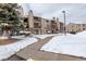 Apartment complex exterior showcasing balconies, brick accents, and snow-covered grounds at 539 Wright St # 102, Lakewood, CO 80228