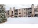 Apartment complex exterior featuring balconies, brick accents, and snow-covered grounds at 539 Wright St # 102, Lakewood, CO 80228