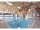 Indoor pool area features a vaulted wood ceiling with skylights and a tranquil blue pool at 539 Wright St # 102, Lakewood, CO 80228